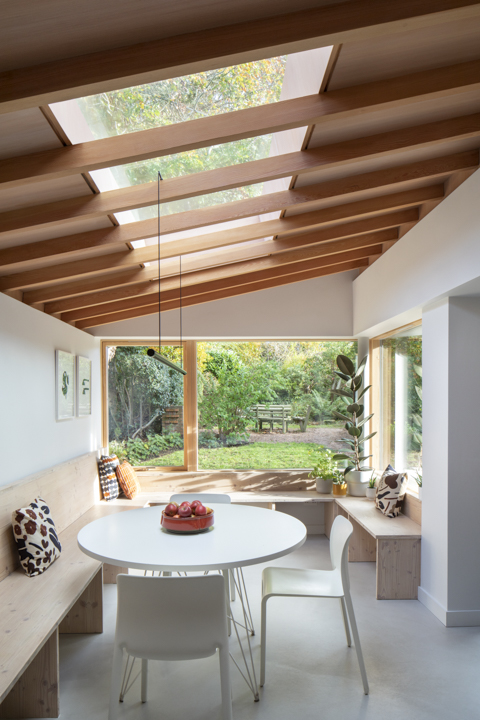 a wooden extension with windows and a dining nook