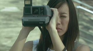 Woman holding a Polaroid camera