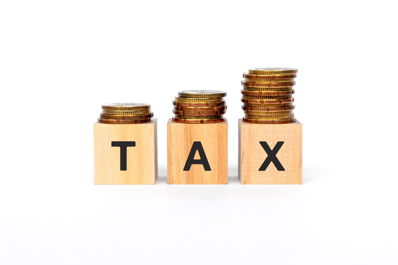 Coins stacked on top of blocks spelling out TAX