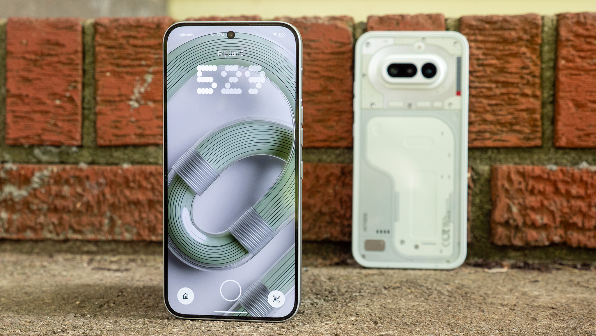 A Nothing Phone 4a Pro and a Nothing Phone 4a on a concrete step