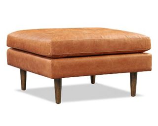 A tan leather coffee table ottoman with dark wooden legs