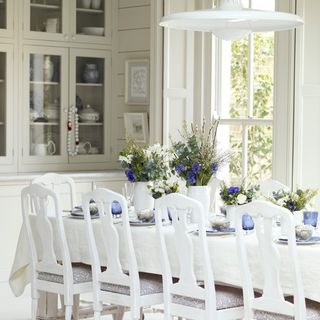 white dining room with flower vases and cabinet
