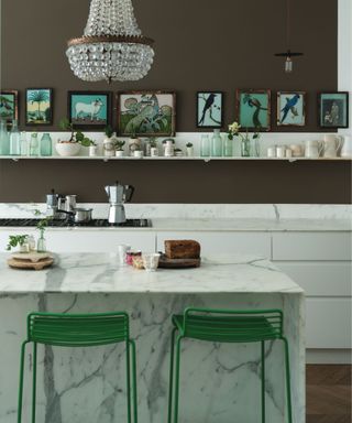 Kitchen with marble counters and marble kitchen islands paired with brown wall paint