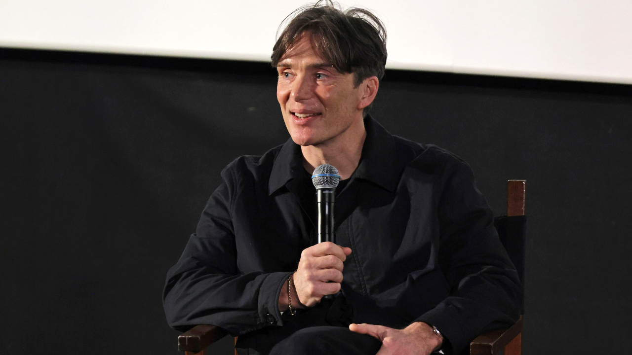 Cillian Murphy smiling with a microphone in his hand