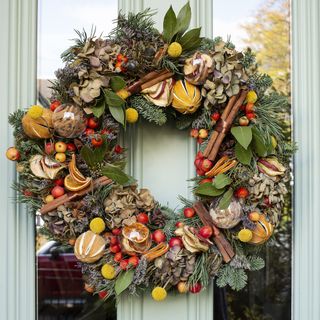 An abundant fresh wreath with dried oranges, dried apple slices, cinnamon, ginger