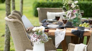 Cottage garden with outdoor rattan dining table and chairs