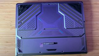 Silver underside of MSI Titan 18 HX gaming laptop showing cooling vents and extra stilts