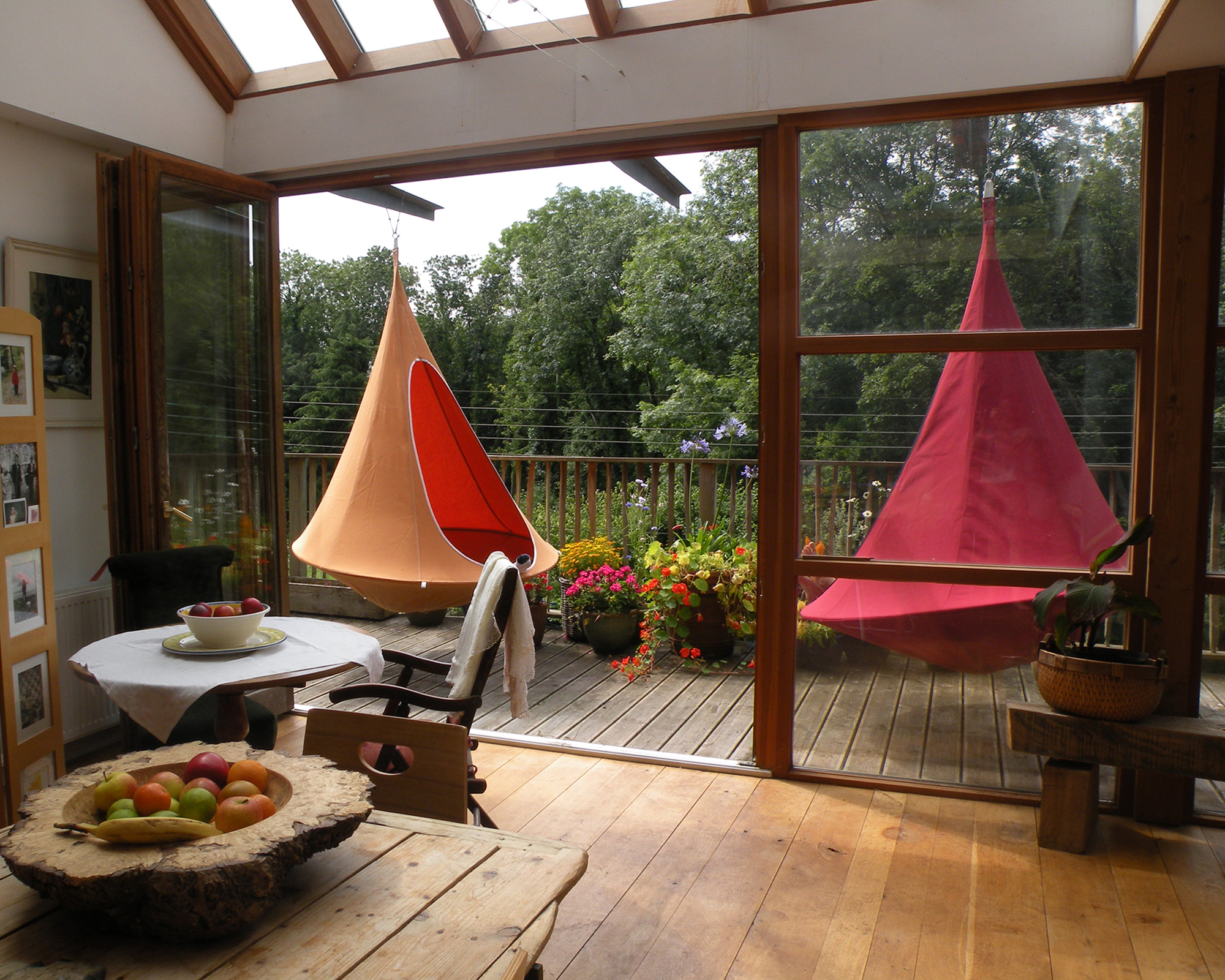 Hanging Cacoon in red and Mango Orange on wooden decking by Cuckooland