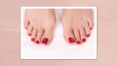 A close-up of two feet with a dark red pedicure/ in a light pink template