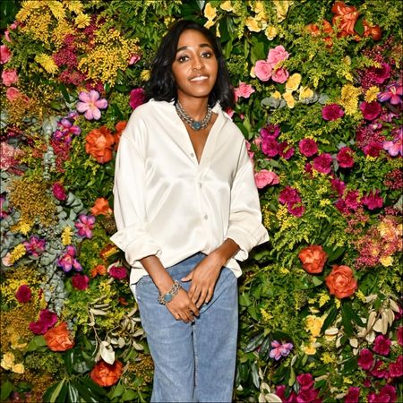 Ayo Edebiri in front of a flower wall