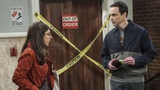 Jim Parsons and Mayim Bialik talk outside the elevator as Sheldon and Amy.