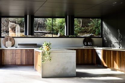 A kitchen designed in wood and concrete, with natural light pouring in