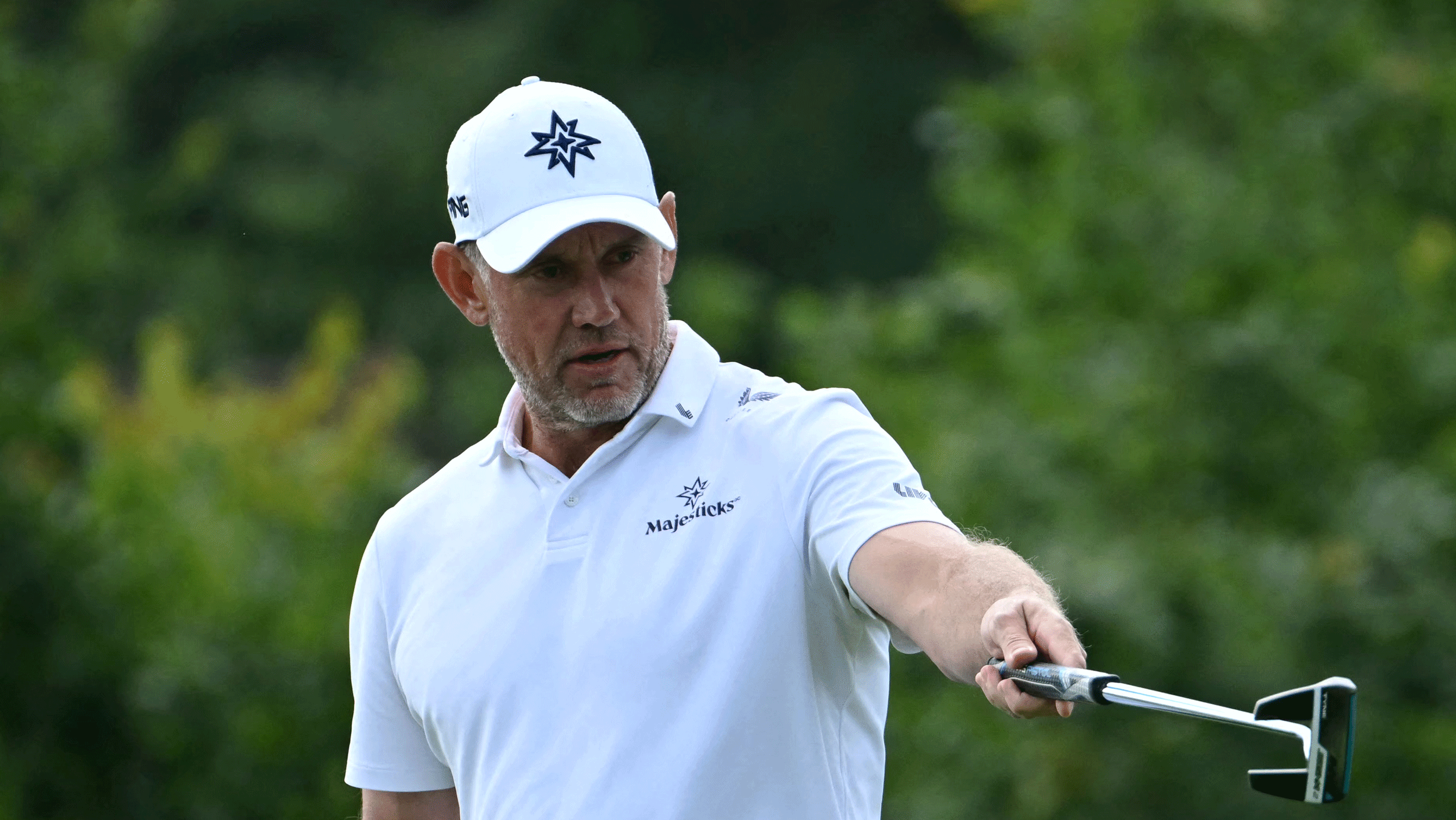 Lee Westwood points at something ahead of him with his putter during 2025