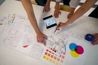 Close-up of an interior designer sketching a design for a house with her clients