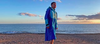 Man on beach wearing White Water Softshell Robe