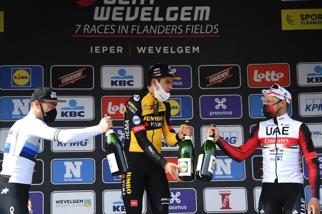 WEVELGEM BELGIUM MARCH 28 Podium Giacomo Nizzolo of Italy and Team Qhubeka Assos Wout Van Aert of Belgium and Team Jumbo Visma Matteo Trentin of Italy and UAE Team Emirates Celebration during the 83rd GentWevelgem in Flanders Fields 2021 Mens Elite a 254km race from Ypres to Wevelgem Celebration Champagne Mask Covid Safety Measures GWE21 GWEmen FlandersClassic on March 28 2021 in Wevelgem Belgium Photo by Tim de WaeleGetty Images