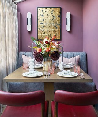 Purple dining room with red leather chairs and small square table