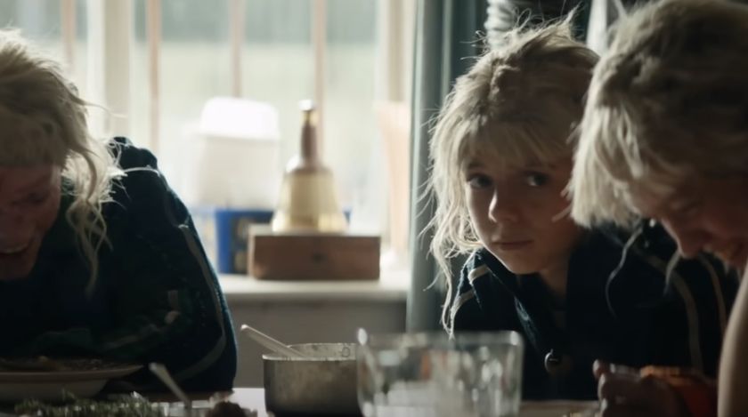 Spike sitting at table with Jimmy Cult members in 28 Years Later: The Bone Temple