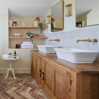 bathroom with a large traditional twin basin vanity unit, mirror, open shelving, and terracotta floor tiles