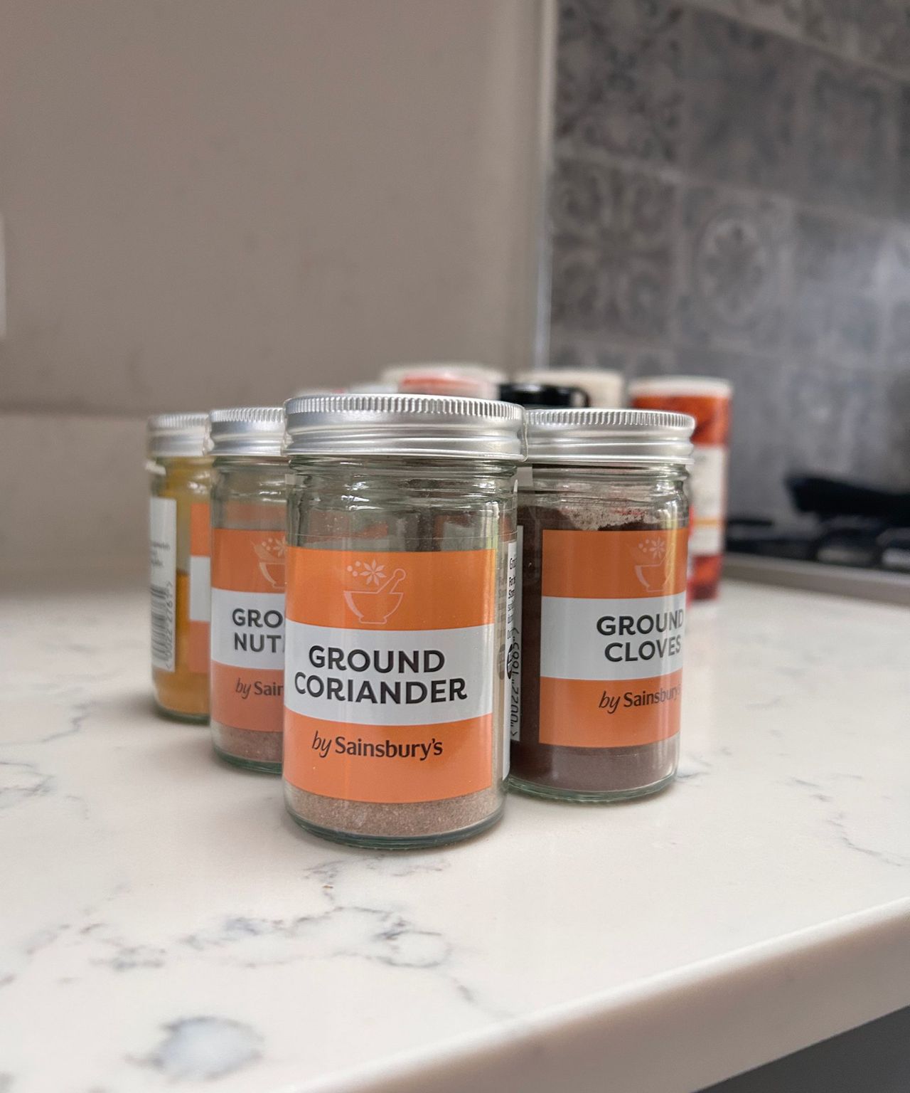Perfectly labelled spices on a white kitchen countertop