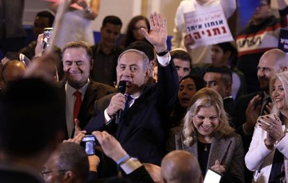 Israeli Prime Minister Benjamin Netanyahu waves to supporters during a Likud party campaign rally in Jerusalem on February 26, 2020. To his right stands his wife Sarah. - Next week's election