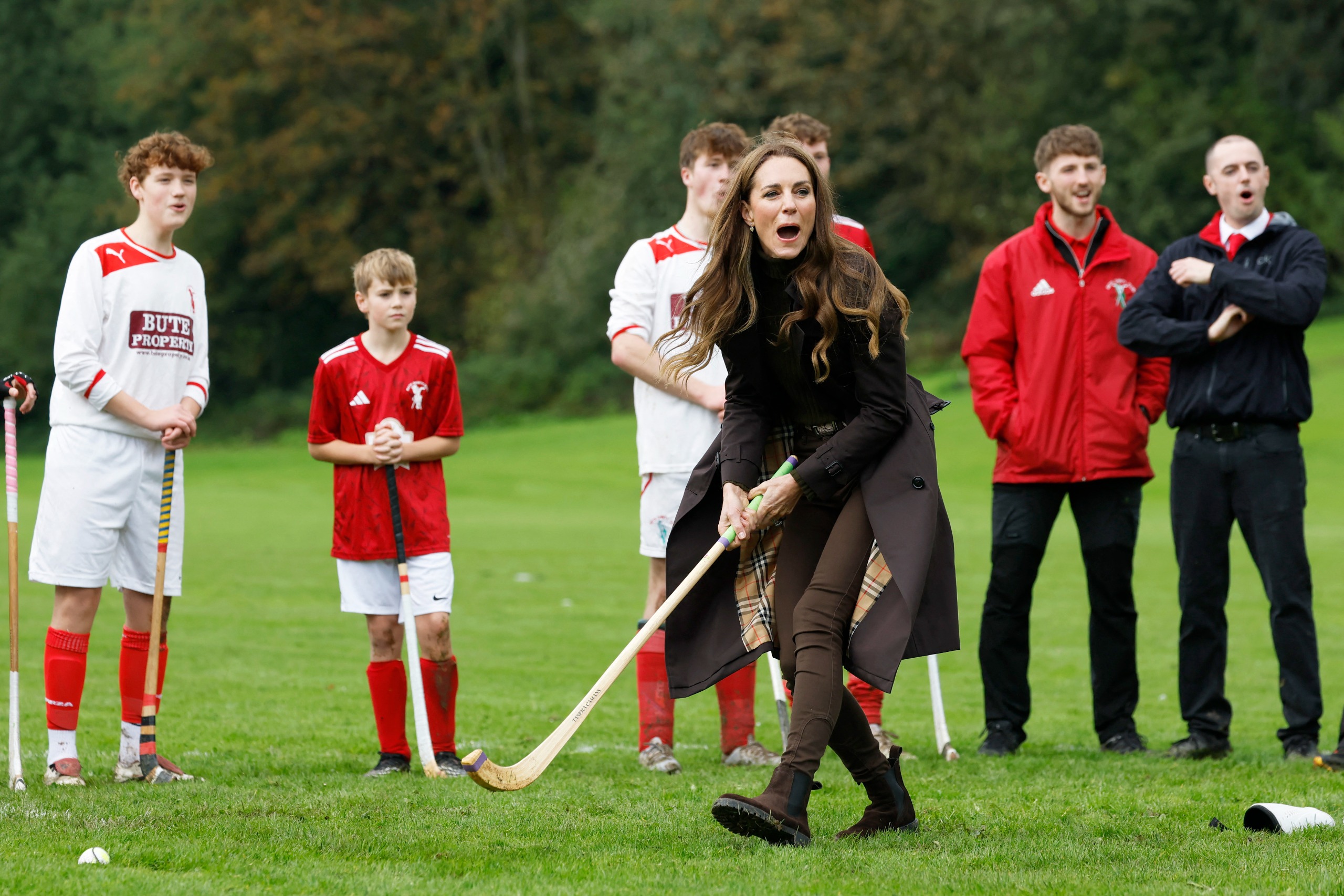 Princess Kate playing shinty as players watch