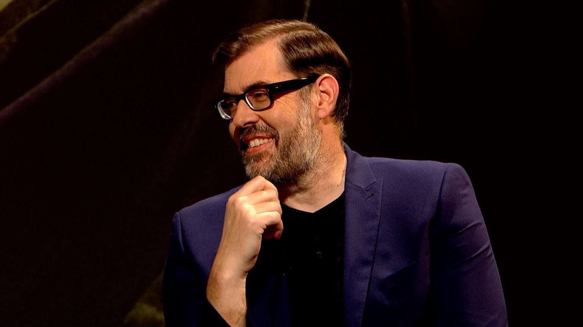 Richard Osman in a blue blazer in an appearance on QI