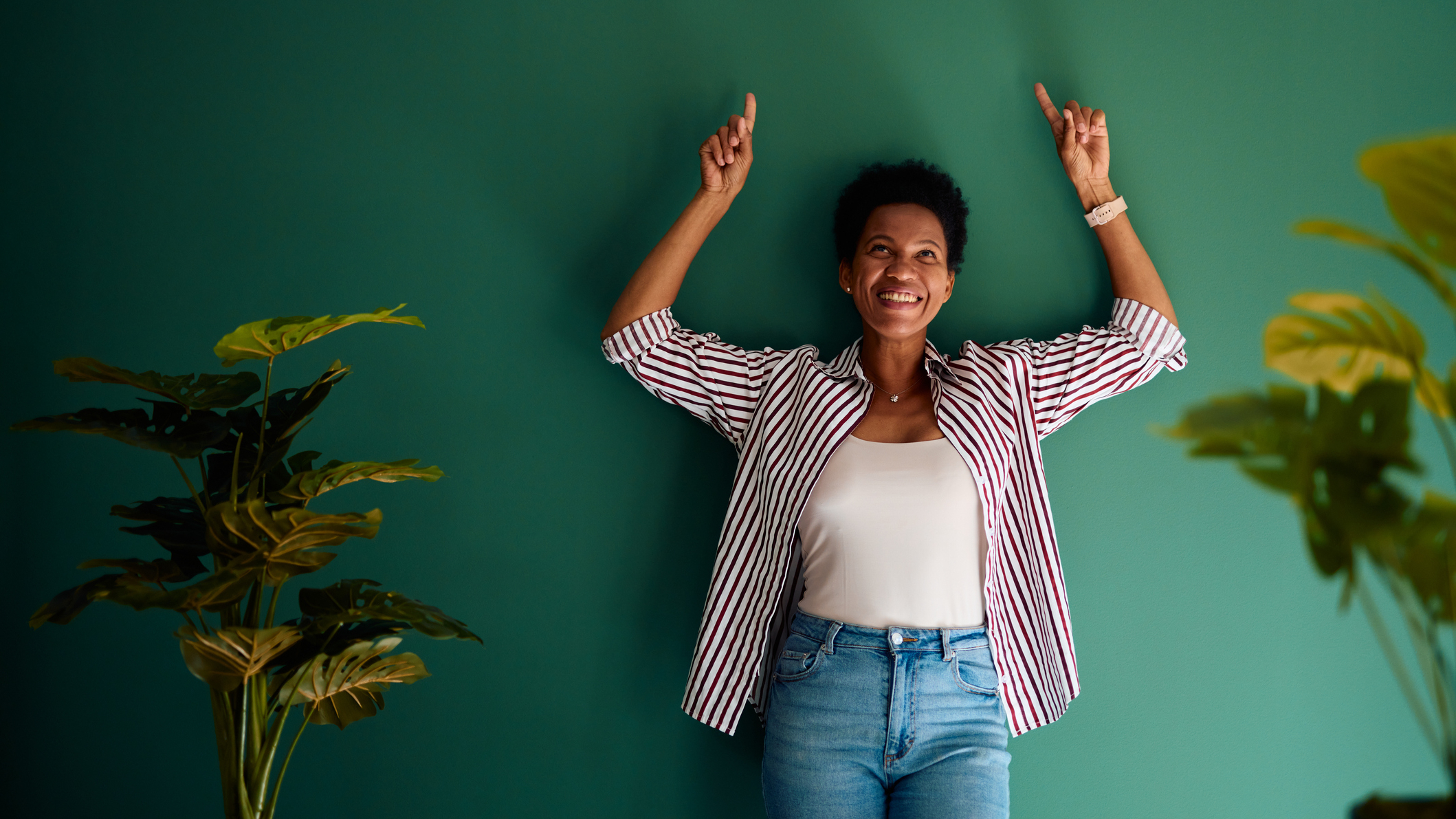 Woman with her back against a wall and arms raised