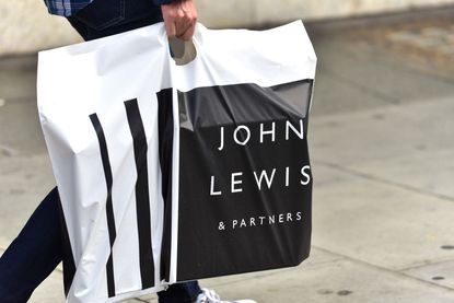 A man carrying a John Lewis and Partners shopping bag