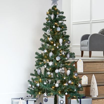 room with christmas tree wooden stairs and white wall