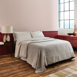 skirting board colour ideas, bedroom with magenta skirting and chair rail, hardwood floor, oatmeal bedding