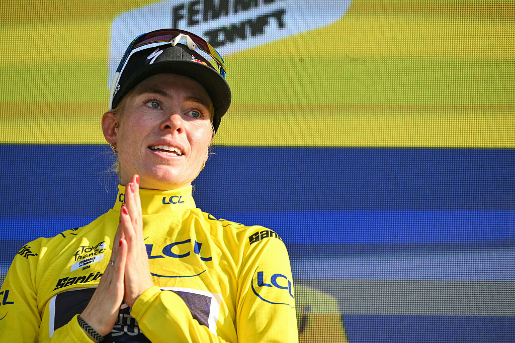 FDJ-SUEZ's Dutch rider Demi Vollering celebrates on the podium wearing the overall leader's yellow jersey