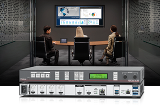 The new MGP 641 xi 5K multi-window processor superimposed in front of two men and a woman in a small conference room.