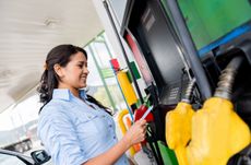 Woman at the gas station paying with credit card