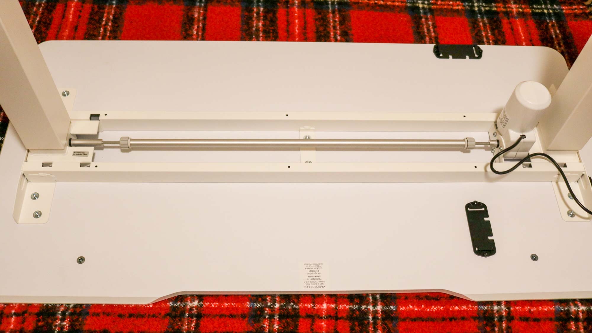 The underside of the Vari Essential Electric standing desk shows the single rod and motor system