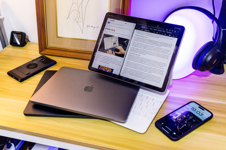 The iPad Air with two MacBook Airs on a desk.