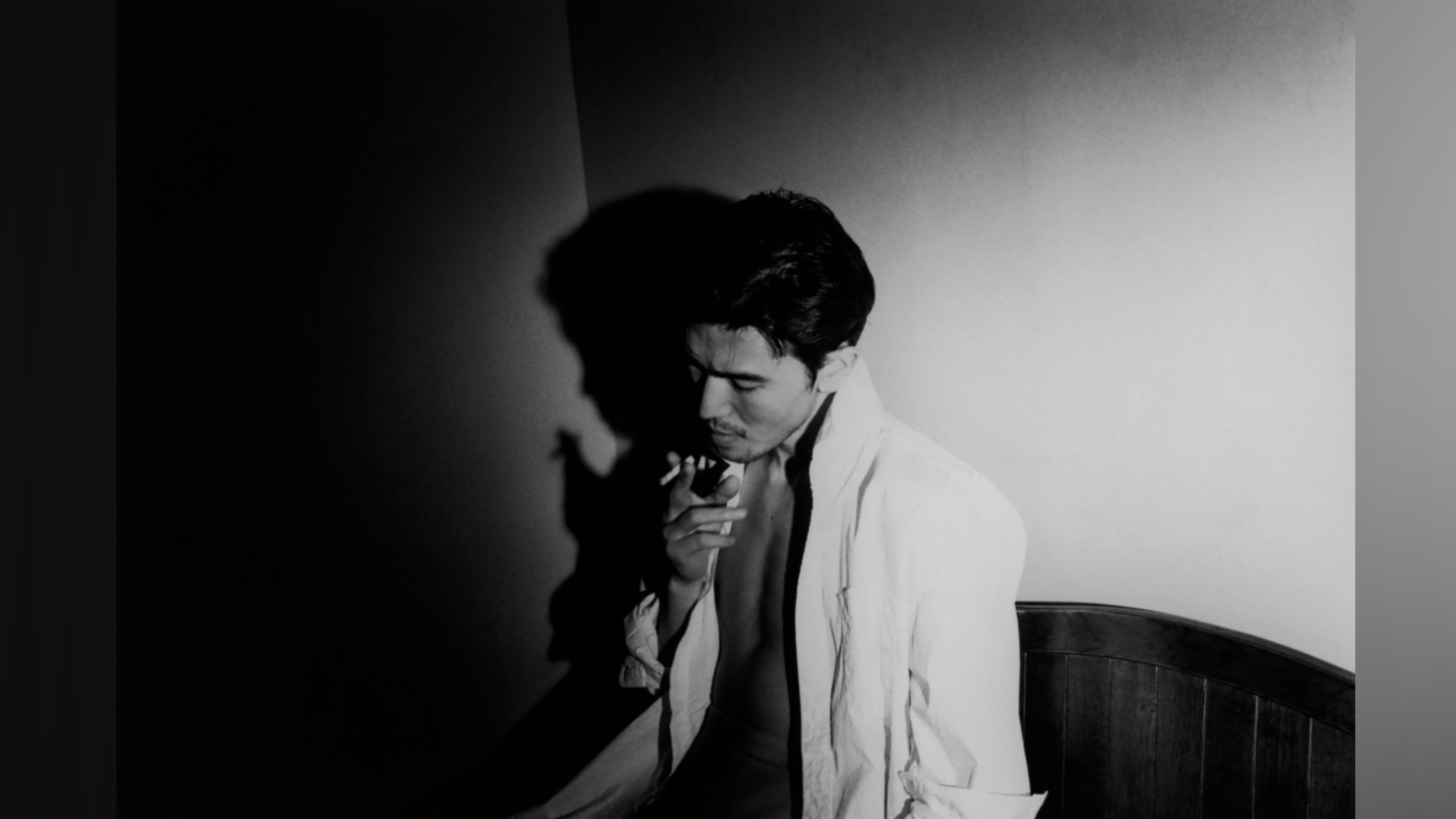 Black and white portrait of a man smoking acigarette.
