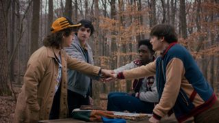 The original "Stranger Things" boys do hands-in in a scene from "Stranger Things" season 5