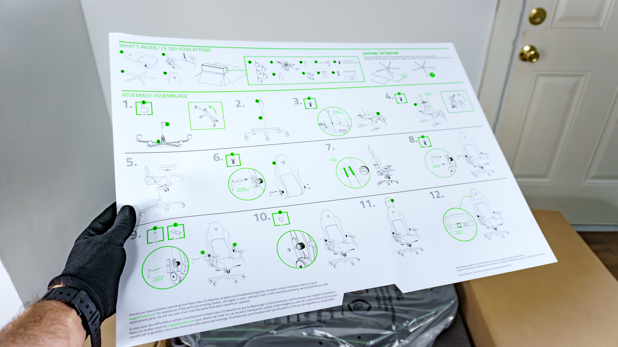 A person holding the Razer Iskur V2 NewGen's printed assembly instructions in hand