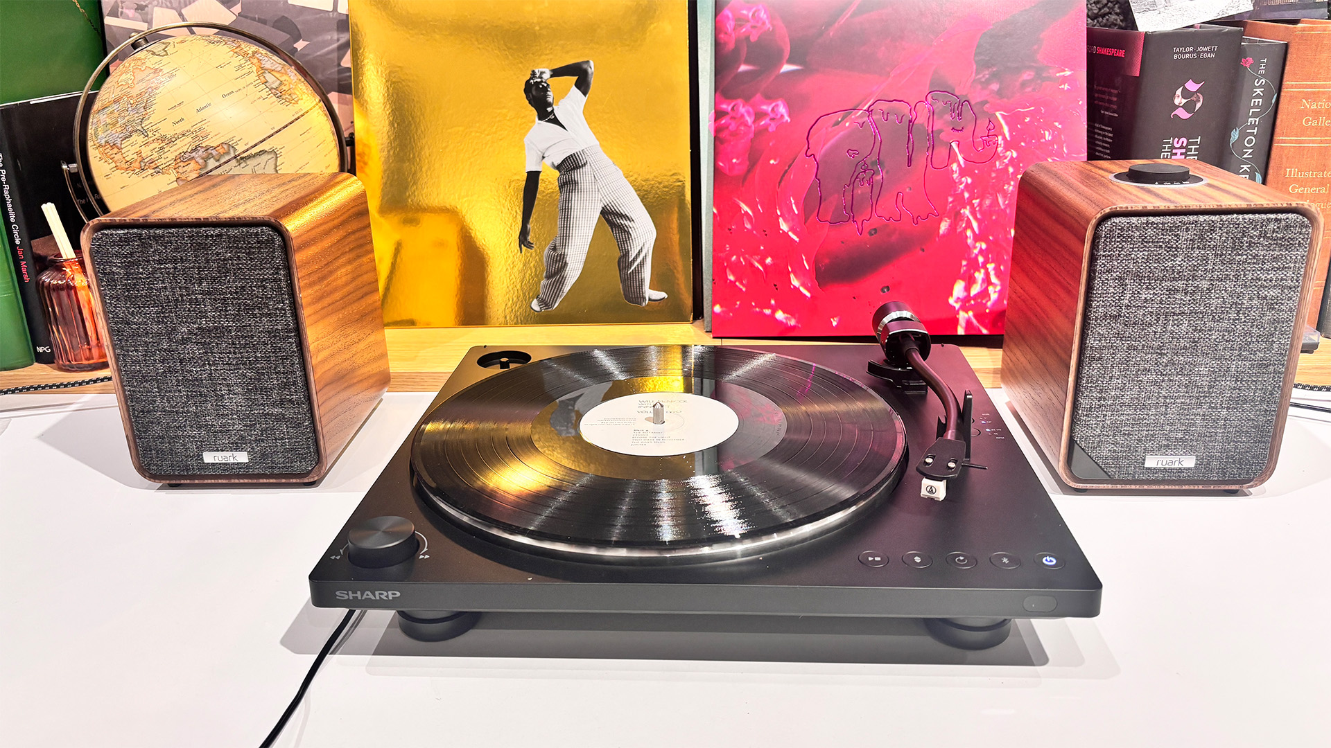 Sharp RP-TT100 Bluetooth turntable in front of vinyl records flanked by Ruark speakers