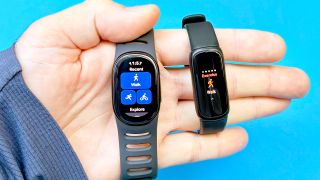 Close-up of the Fitbit Edge next to the Fitbit Inspire 3 in a user's hand against a blue background