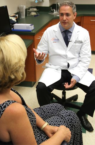 Dr. Jeffrey Feiner consults with Amy Caterina about a specialized surgery for patients with lymphedema. Caterina made the 2,500 mile trip from San Diego, Calif., to undergo the procedure at UF Health Cancer Center - Orlando Health, one of the few hospitals in the country to offer it. More Americans are booking vacations centered around medical treatments in a trend known as "domestic medical tourism."