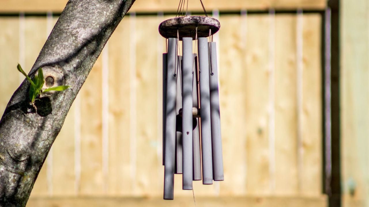 Windchimes in front of a fence panel