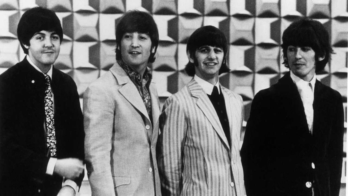 The Beatles posing for a photo at a press conference