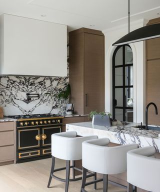 kitchen with marble backsplash and white bar stools