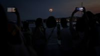The Sun's corona glows as the Moon completely blocks the Sun during the totality phase of the total solar eclipse as seen from the sea port of Tarragona, northeastern Spain, on August 12, 2026. Millions of Europeans contemplated the sky in awe today during a rare total solar eclipse that will plunge a swathe of Spain into an eerie daytime darkness. The shadow cast when the Moon covers the Sun began in Russia's remote Arctic north at around 1700 GMT and continued in an arc through Greenland and Iceland. Spain is where most people viewed the total eclipse, which crossed the country diagonally from the northern Atlantic coast to the Mediterranean Sea, where it vanished at around 1830 GMT. (Photo by Josep LAGO / AFP via Getty Images)