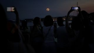 The Sun's corona glows as the Moon completely blocks the Sun during the totality phase of the total solar eclipse as seen from the sea port of Tarragona, northeastern Spain, on August 12, 2026. Millions of Europeans contemplated the sky in awe today during a rare total solar eclipse that will plunge a swathe of Spain into an eerie daytime darkness. The shadow cast when the Moon covers the Sun began in Russia's remote Arctic north at around 1700 GMT and continued in an arc through Greenland and Iceland. Spain is where most people viewed the total eclipse, which crossed the country diagonally from the northern Atlantic coast to the Mediterranean Sea, where it vanished at around 1830 GMT. (Photo by Josep LAGO / AFP via Getty Images)
