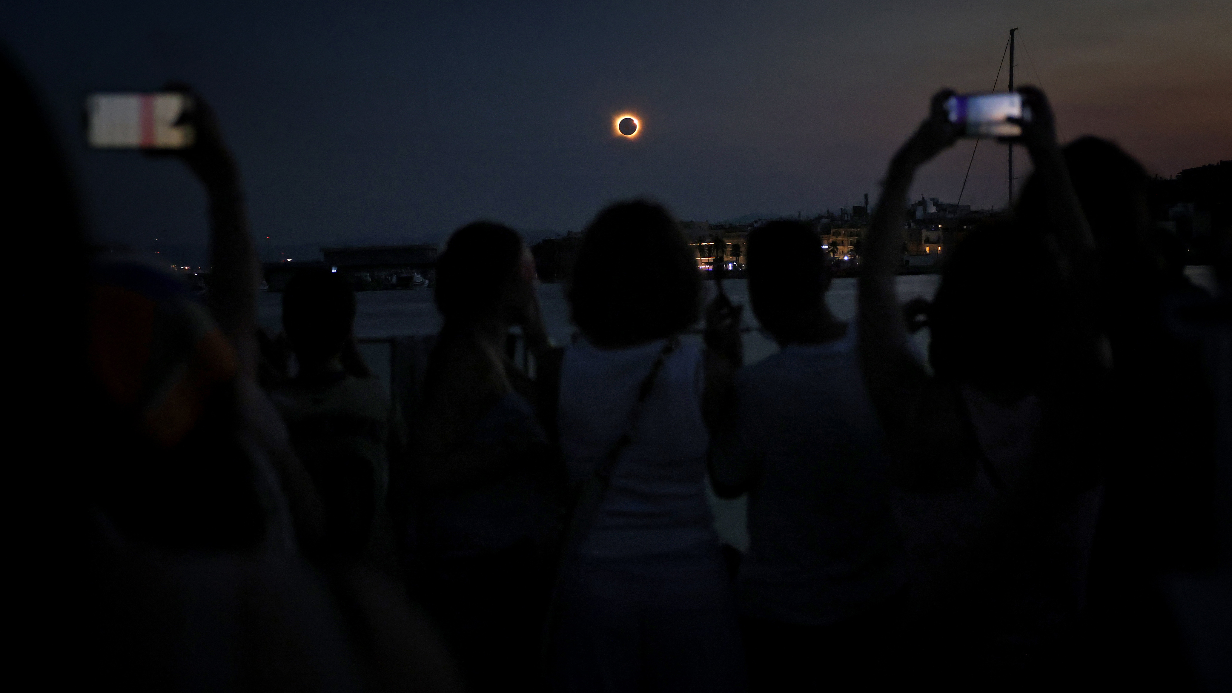 The Sun's corona glows as the Moon completely blocks the Sun during the totality phase of the total solar eclipse as seen from the sea port of Tarragona, northeastern Spain, on August 12, 2026. Millions of Europeans contemplated the sky in awe today during a rare total solar eclipse that will plunge a swathe of Spain into an eerie daytime darkness. The shadow cast when the Moon covers the Sun began in Russia's remote Arctic north at around 1700 GMT and continued in an arc through Greenland and Iceland. Spain is where most people viewed the total eclipse, which crossed the country diagonally from the northern Atlantic coast to the Mediterranean Sea, where it vanished at around 1830 GMT. (Photo by Josep LAGO / AFP via Getty Images)