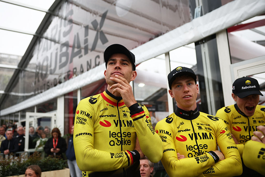 Team Visma - Lease a Bike's Belgian rider Wout van Aert (L) and British rider Matthew Brennan stand with teammates during the teams' presentations event on the eve of Paris-Roubaix 