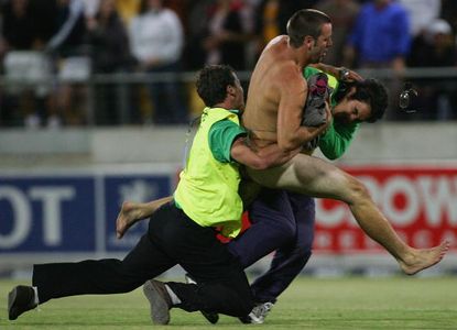 A streaker in Australia is tackled by security guards.
